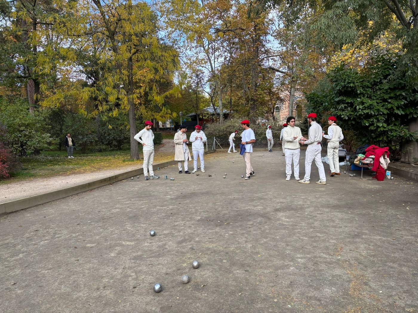 Partida de otoño en el Retiro: bolas sobre la tierra y miembros de blanco entre los árboles